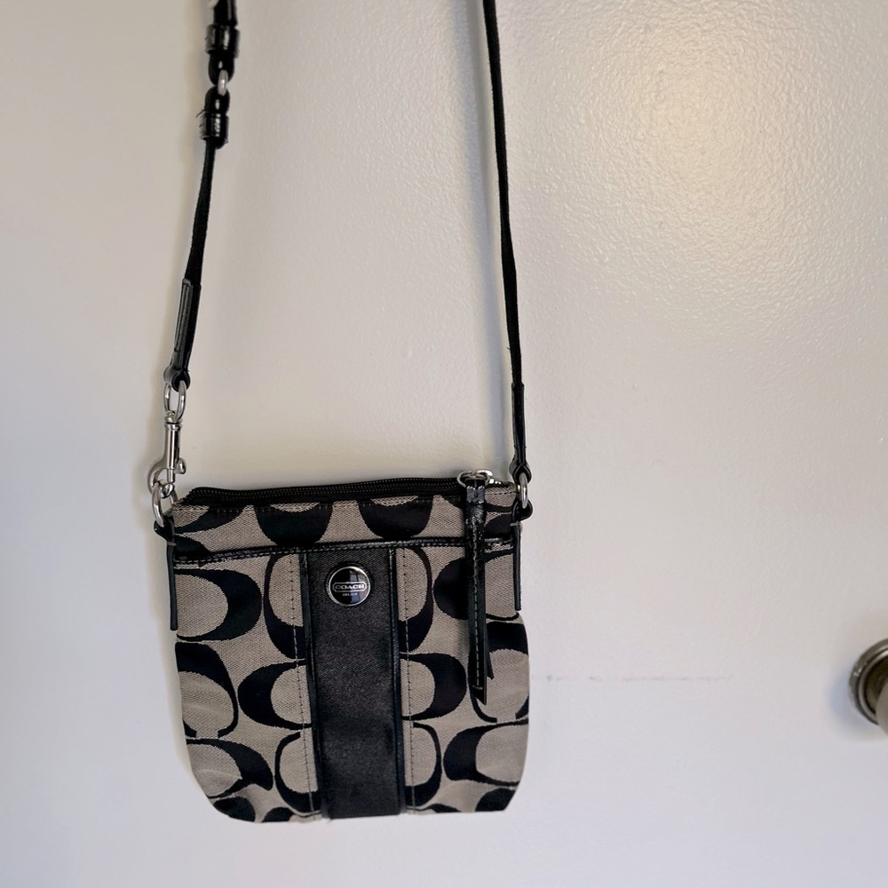 Signature Coach black small crossbody purse.